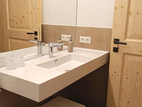 a bathroom with a white sink and a mirror at Gästehaus Maier in Kitzbühel