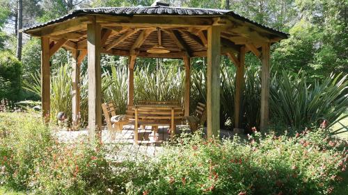 a wooden gazebo with a table and chairs in a garden at Maison de campagne - 5 chambres in Capdrot