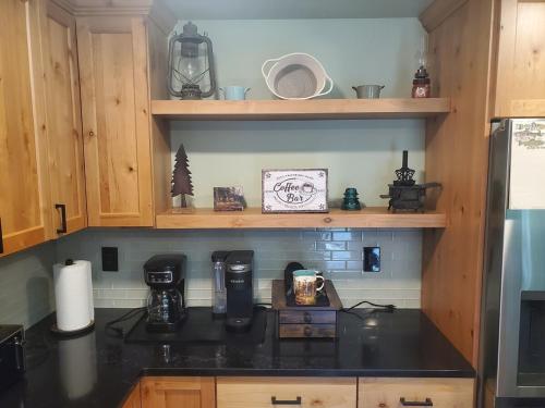 a kitchen with a black counter top and wooden cabinets at Tony's Riverside Oasis in Sultan