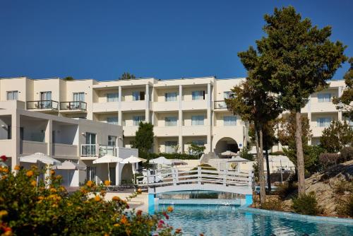a hotel with a swimming pool and a resort at Kiotari Bay in Kiotari