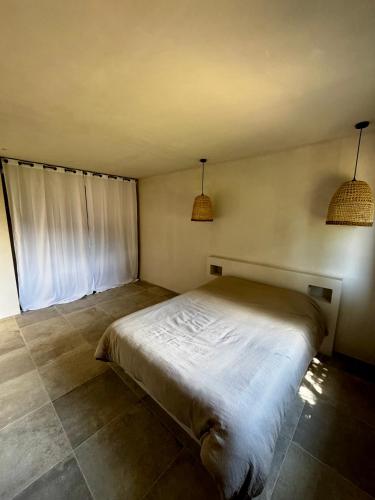 Ce lit se trouve dans un dortoir doté de 2 lampes suspendues. dans l'établissement Rez-de-villa 65m2, à Propriano