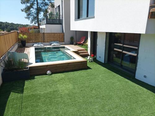 une cour avec une piscine et de l'herbe verte dans l'établissement Agréable villa familiale avec piscine, à Prades-le-Lez