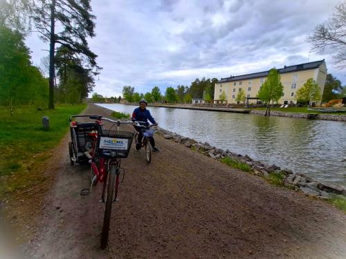 a man riding his bike on a path next to a river at Norrqvarn Hotel & Resort by Vänerport in Lyrestad