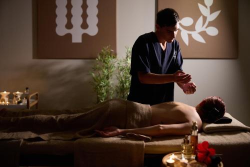 a man getting a massage from a therapist at Kiotari Bay in Kiotari
