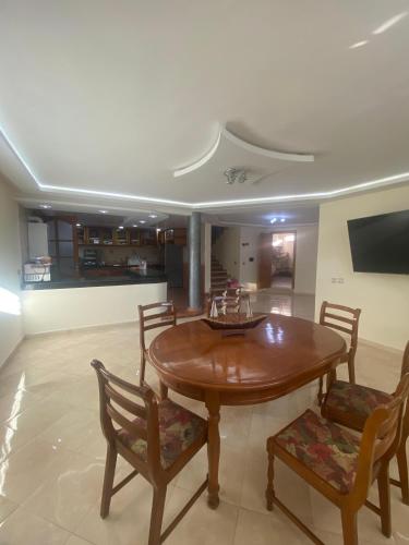 a dining room with a wooden table and chairs at coastal charm harhoura in Temara