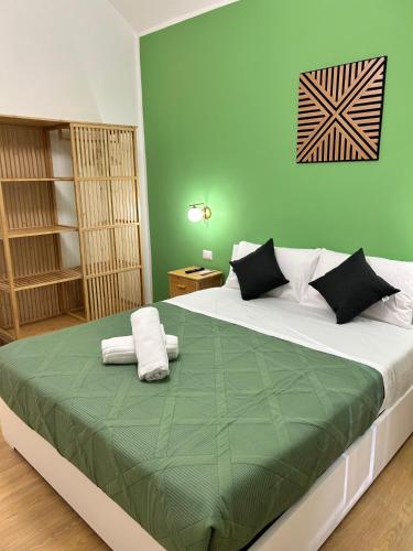a bedroom with a large bed with green walls at San Peter Lory's Aparts in Rome