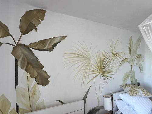 a bedroom with a mural of plants on the wall at SEAHORSE POINT HOTEL and NATURE RESERVE in Bocas del Toro