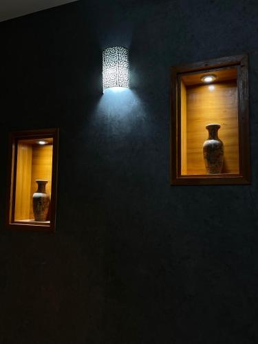 two vases sitting on a wall with a light at coastal charm harhoura in Temara
