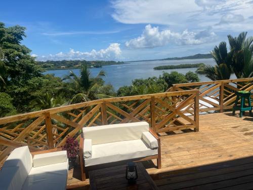 a deck with two chairs and a view of the water at SEAHORSE POINT HOTEL and NATURE RESERVE in Bocas del Toro