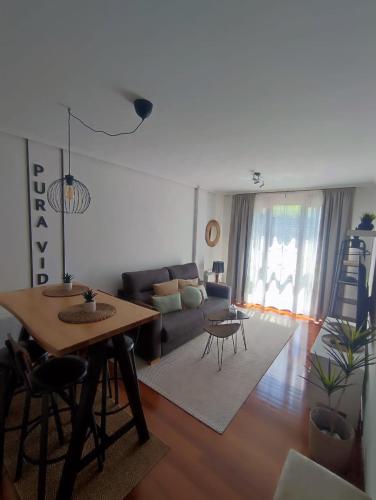 a living room with a table and a couch at Pura Vida Apartmento in Ramales de la Victoria