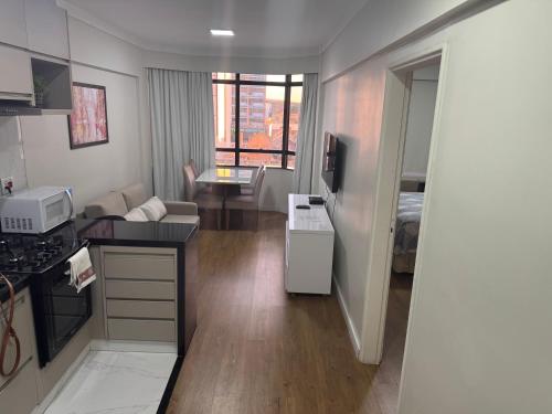 a room with a kitchen and a living room at Flat mobiliado 45 - L Hirondelle in Campinas