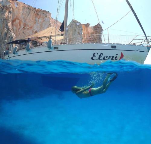 a mermaid in the water in front of a boat at Hotel Eleni in Adamas