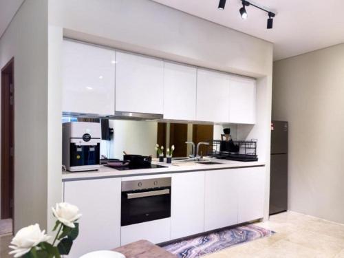 a white kitchen with white cabinets and appliances at Sky Suites KLCC By Star Apartment in Kuala Lumpur