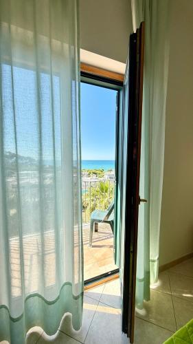 a sliding glass door with a view of the ocean at Ibisco Hotel in Rodi Garganico