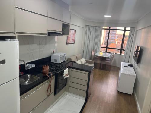 a kitchen with a sink and a counter top at Flat mobiliado 45 - L Hirondelle in Campinas