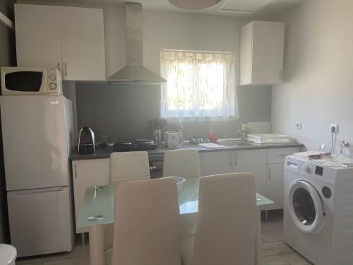 a kitchen with a glass table and white appliances at Casa do Canto in Torre de Moncorvo