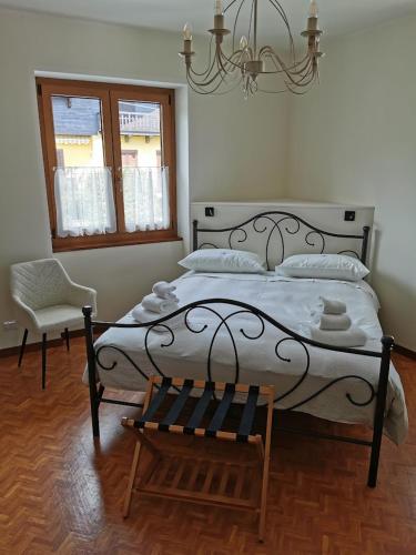 a bedroom with a bed and a chair and a chandelier at Rosso di Sera B & B in Pralungo