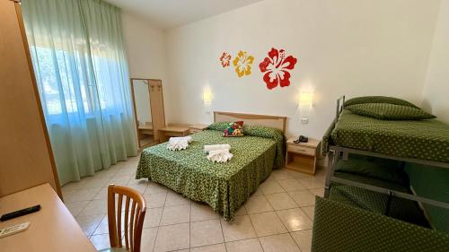 a room with two beds and a table and a table at Ibisco Hotel in Rodi Garganico