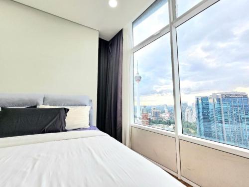a bedroom with a white bed and a large window at Sky Suites KLCC By Star Apartment in Kuala Lumpur
