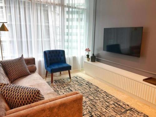 a living room with a couch and a television at Sky Suites KLCC By Star Apartment in Kuala Lumpur