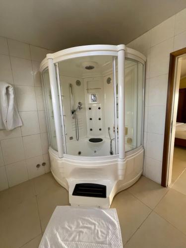 a bathroom with a large shower in a room at Hotel Barmoi in Freetown