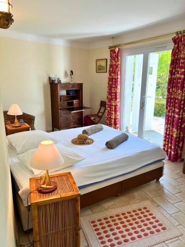 une chambre avec un grand lit et une fenêtre dans l'établissement Villa-Cyprès-La-Polynésie-Giens, à Hyères