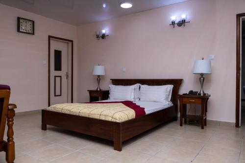 a bedroom with a bed with two night stands and two lamps at Hotel Barmoi in Freetown
