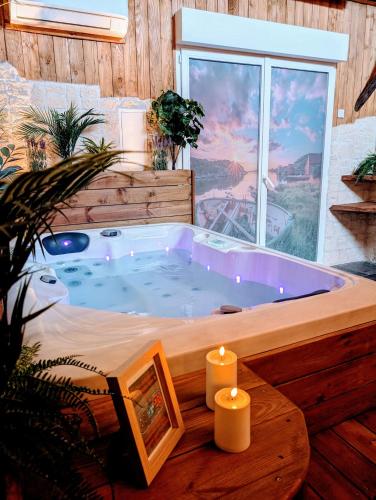a jacuzzi tub in a room with a window at Les Spas de la mer, Appart&Spa Canopée, 100m de la plage, Love Room in Le Grau-du-Roi