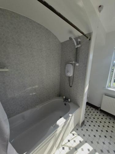 a bath tub in a bathroom with a tiled floor at The Shamrock B&B - Inis Oírr, Aran Islands in Inisheer