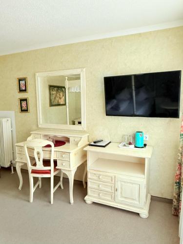 a room with a desk and a desk with a mirror at Hotel Achentalerhof in Achenkirch