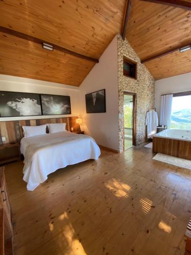 オウロ・プレットにあるSuíte Ad`vinhoの広いベッドルーム(ベッド1台、バスタブ付)