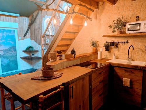 a kitchen with a wooden counter with a sink and stairs at Les Spas de la mer, Appart&Spa Canopée, 100m de la plage, Love Room in Le Grau-du-Roi