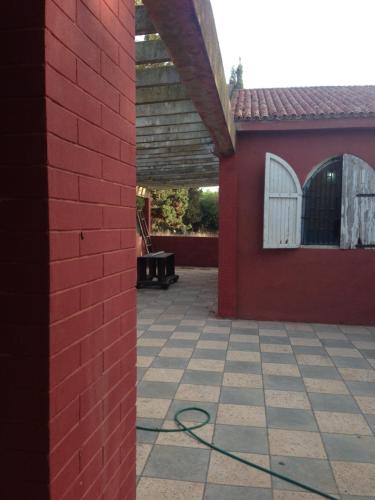 a red brick building with a hose on a patio at Houria in Oulad Akkou