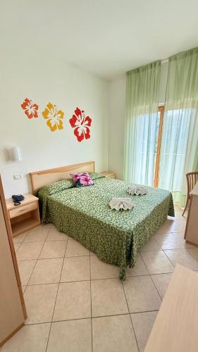 a bedroom with a bed with a green comforter at Ibisco Hotel in Rodi Garganico