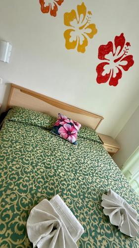 a bedroom with a bed with flowers on the wall at Ibisco Hotel in Rodi Garganico