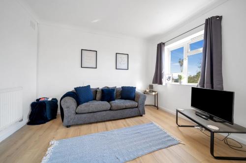 a living room with a couch and a tv at Chic Colchester Flat in Colchester