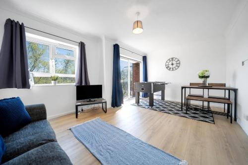 a living room with a couch and a desk at Chic Colchester Flat in Colchester