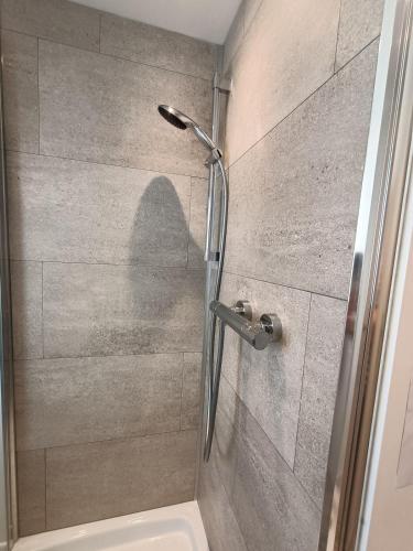 une douche avec une porte vitrée avec une ombre sur le mur dans l'établissement Maison de pêcheur à 900 mètres de la plage de Malo, à Dunkerque