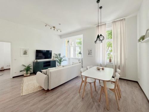a white living room with a couch and a table at Deichstadt Apartments in Neuwied
