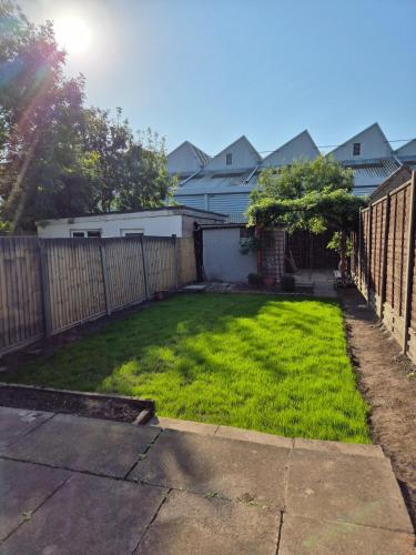 a backyard with a fence and green grass at Bellavita brand new room in Canley
