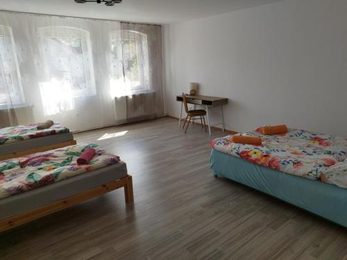 a room with two beds and a desk in it at Agroturystyka Puchatek in Rebiszów