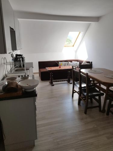 a kitchen and living room with a table and a couch at Agroturystyka Puchatek in Rebiszów