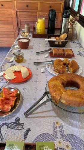 un tavolo con sopra del cibo con piatti di cibo di Residencial das Araucárias a Gonçalves