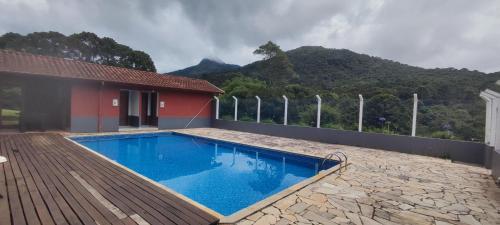una piscina azul frente a una casa en Residencial das Araucárias, en Gonçalves