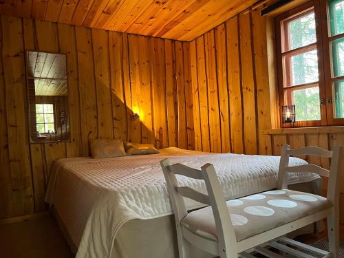 a bedroom with a bed and two chairs in it at Hölmölä in Salo