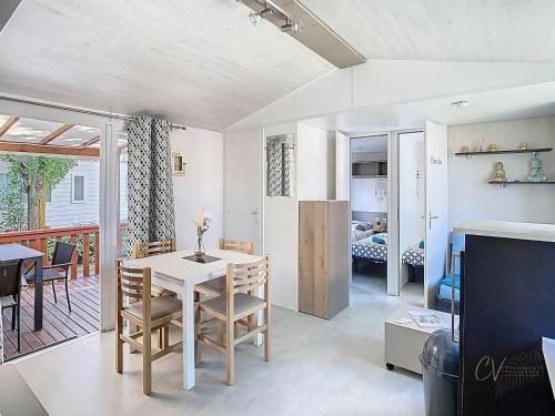 une salle à manger et un salon avec une table et des chaises dans l'établissement Mobil-Home CL 14 à Vias - La Carabasse - Camping Siblu avec piscine, à Vias