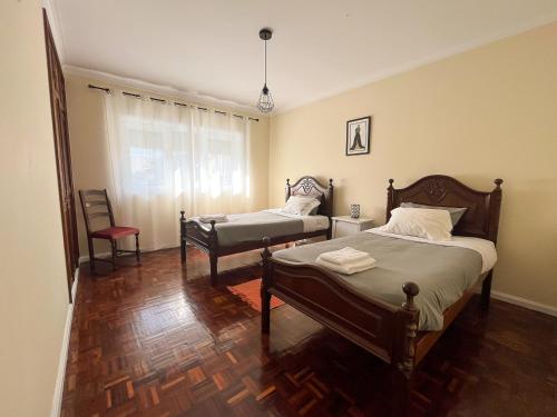 een slaapkamer met 2 bedden en een stoel bij Spacious Villa in Vila Nova de Gaia in Vila Nova de Gaia