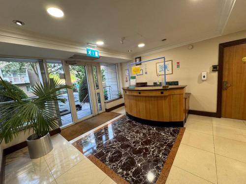 a lobby with a bar and a potted plant at 1 Bedroom Apartment with security 24 hours in London
