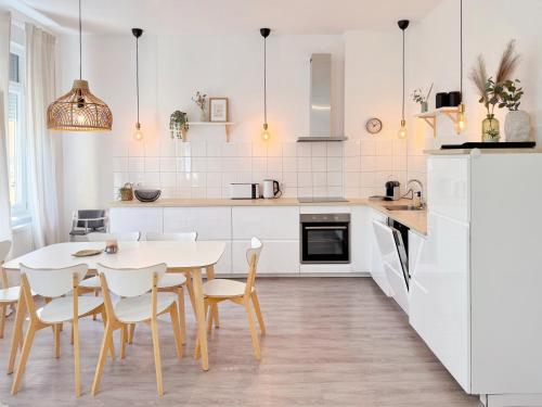a white kitchen with a table and chairs at Deichstadt Apartments in Neuwied