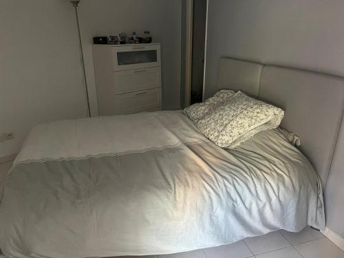 Ce lit se trouve dans une chambre dotée d'un couvre-lit blanc. dans l'établissement Charming two-room with garage, à Menton
